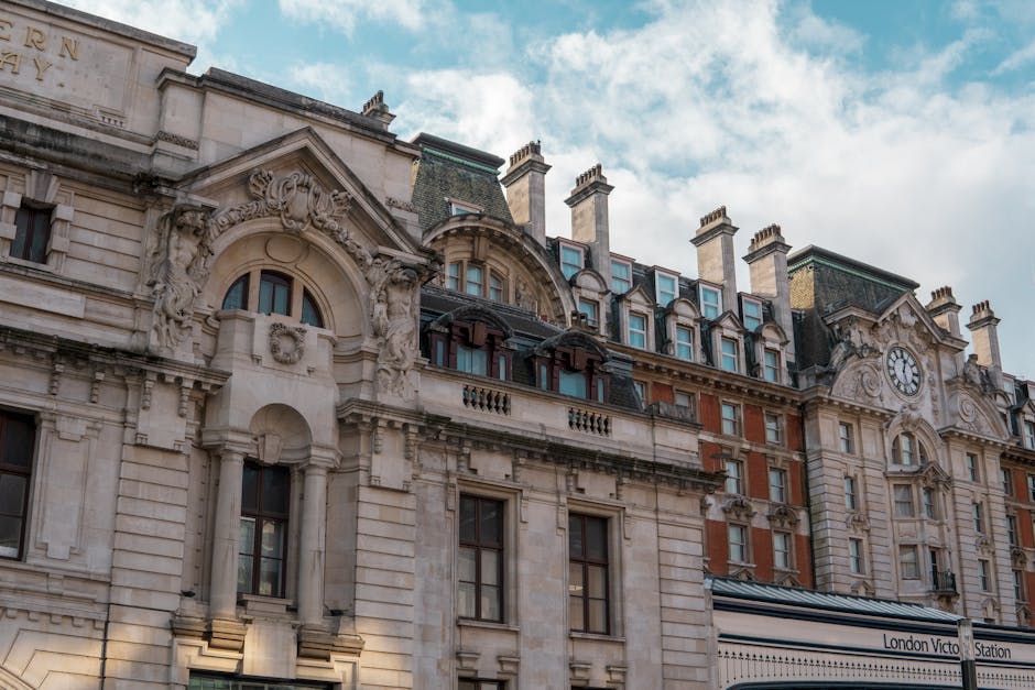 A close-up view of Victoria Palace, part of the historic Victoria Palace building, featuring a white stone façade with classical architectural elements such as columns, pediments, and decorative scul